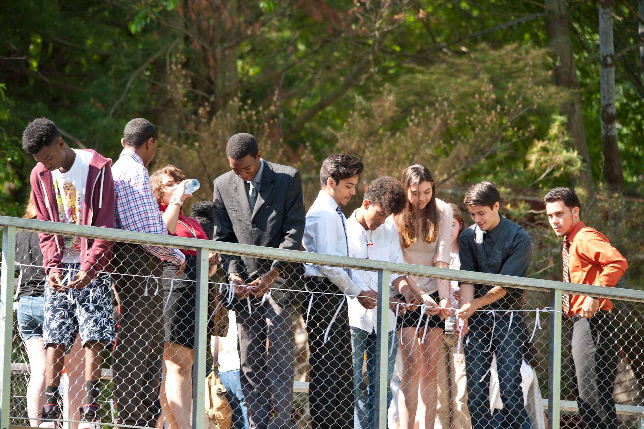 Students tie wishes written on ribbons to the bridge of the new Common Ground High School building.